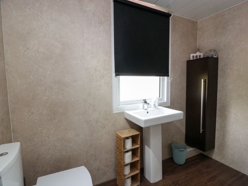 A bathroom with a toilet and sink at Wagtail Cottage Southerness