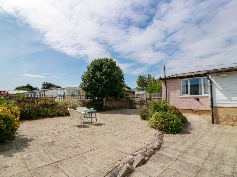 An outdoor area with a table and chairs at Wagtail Cottage in Southerness