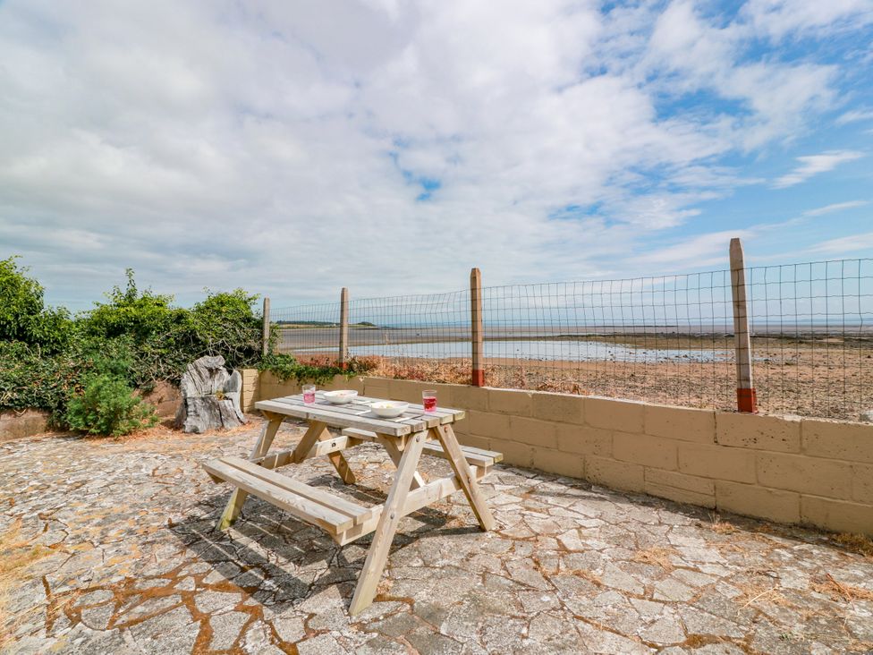 An outdoor area with a picnic table and a view at Wagtail Cottage in Southerness