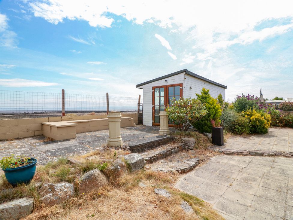 An outdoor area with a cabin and plants at Wagtail Cottage in Southerness