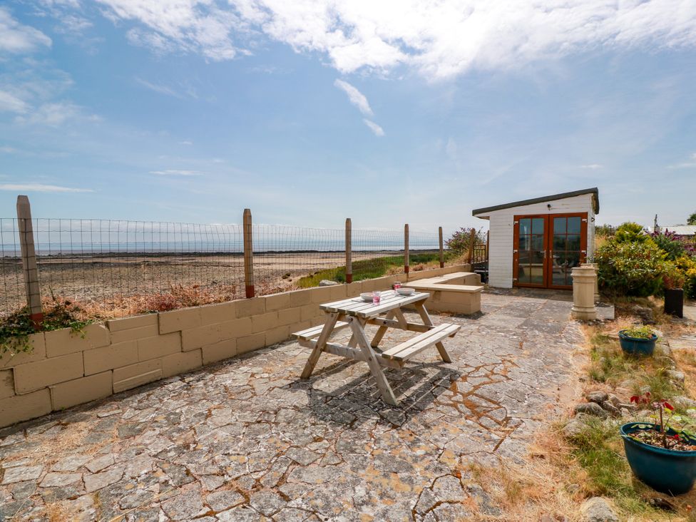 An outdoor patio area with a table and chairs at Wagtail Cottage in Southerness
