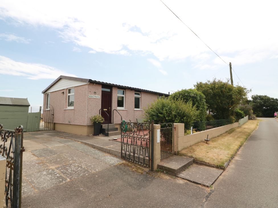 A house with a driveway and garden at Wagtail Cottage in Southerness