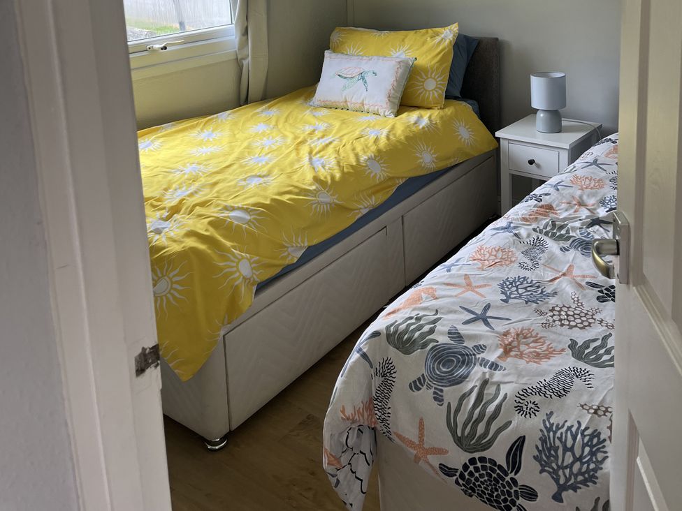 A bedroom with two beds and a nightstand at Chalet - Buckland 16, Bideford