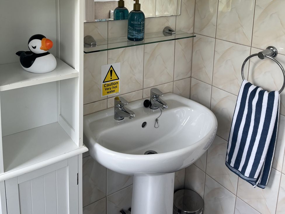 A bathroom with a wash basin and a decorative figure at Chalet - Buckland 16 in Bideford
