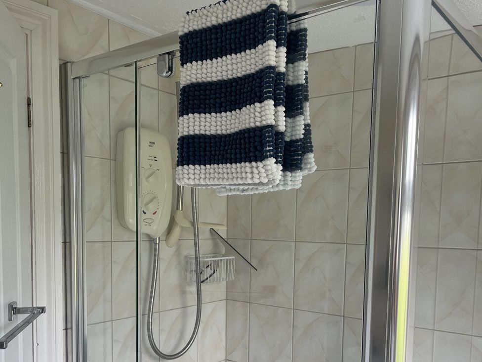 A shower with a towel hanging and a control panel at Chalet - Buckland 16, Bideford