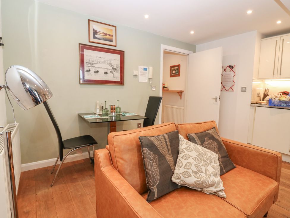 A living room with a sofa, table, and chair at Mill Wharf in Berwick-upon-Tweed