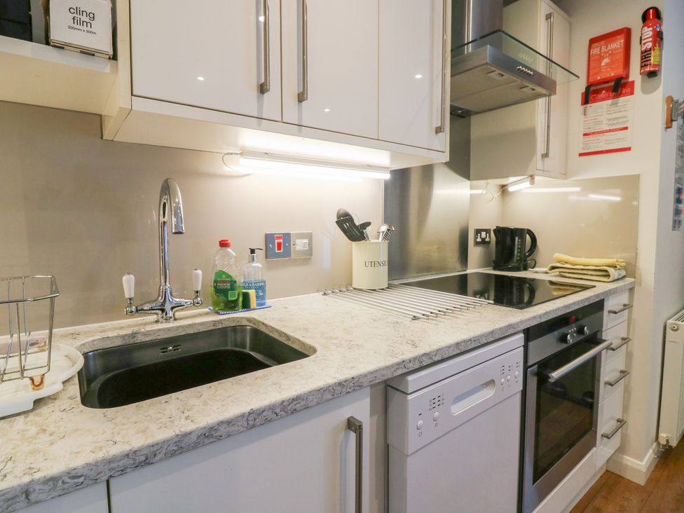 A kitchen with a sink, stovetop, and dishwasher at Mill Wharf in Berwick-upon-Tweed