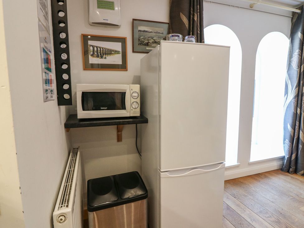 A kitchen area with a microwave and refrigerator at Mill Wharf in Berwick-upon-Tweed