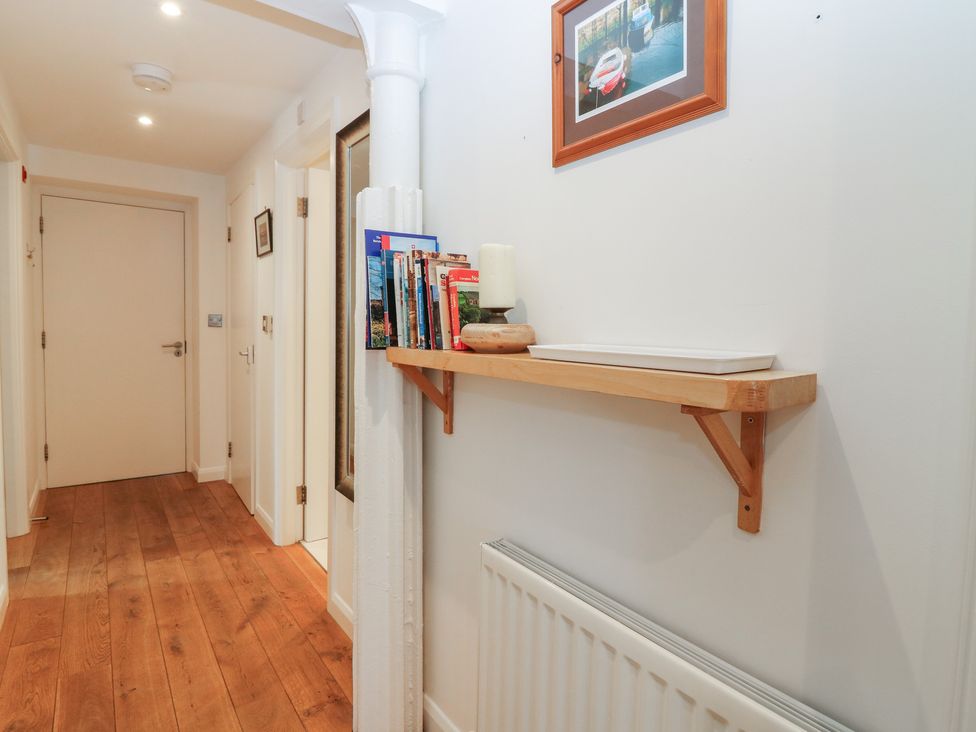 A hallway with a wooden shelf and books at Mill Wharf in Berwick-upon-Tweed