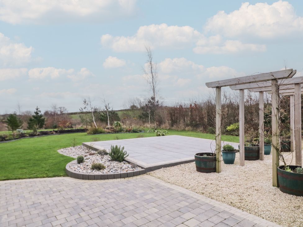 A garden with a concrete patio and planters at The Loft - 96B