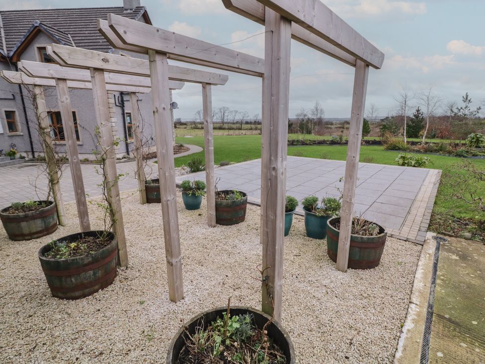 A garden with wooden structure and potted plants at The Loft - 96B
