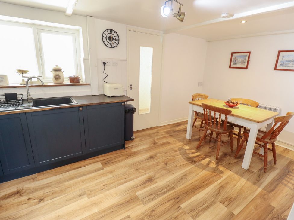 A kitchen with a sink, countertop, table and chairs at 3 Rectory Row