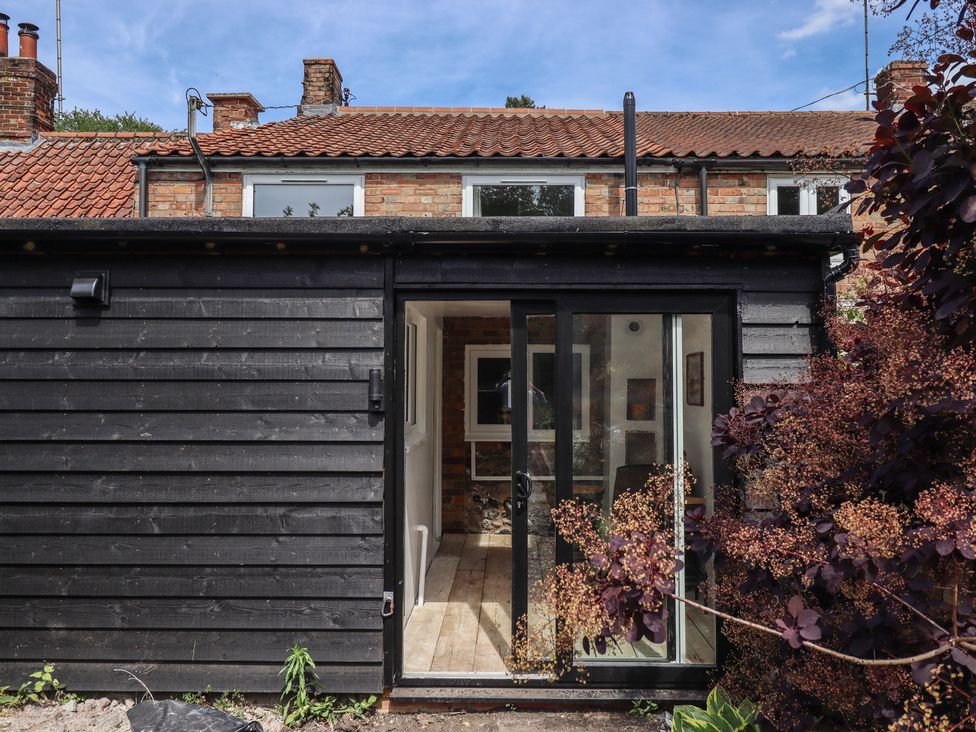 A black wooden structure with a glass door at 3 Rectory Row