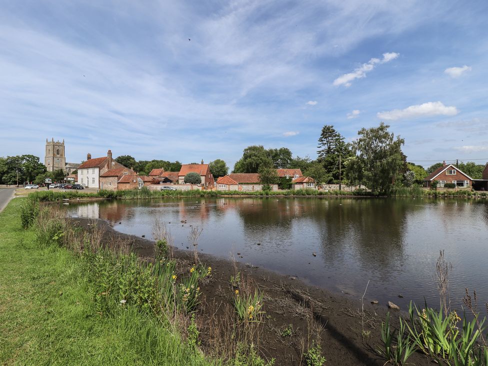 A view of a pond with houses and a church at 3 Rectory Row in 