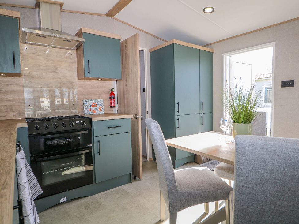 A kitchen with cabinets and dining table at South Beach Landings 28 in Camber