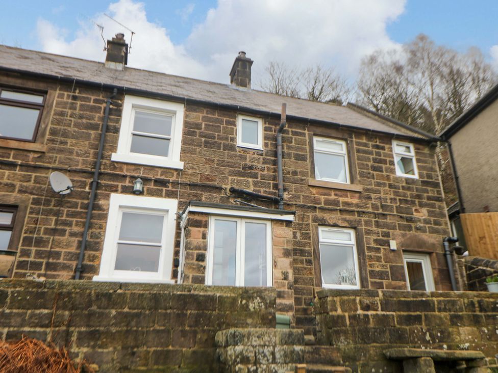 A stone building with windows and a satellite dish at Nature’s Retreat in Matlock