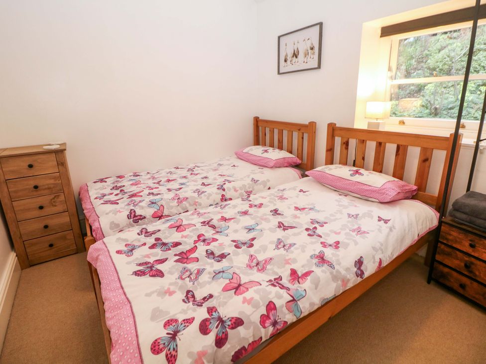 A bedroom with two single beds and a bedside table at Nature’s Retreat in Matlock