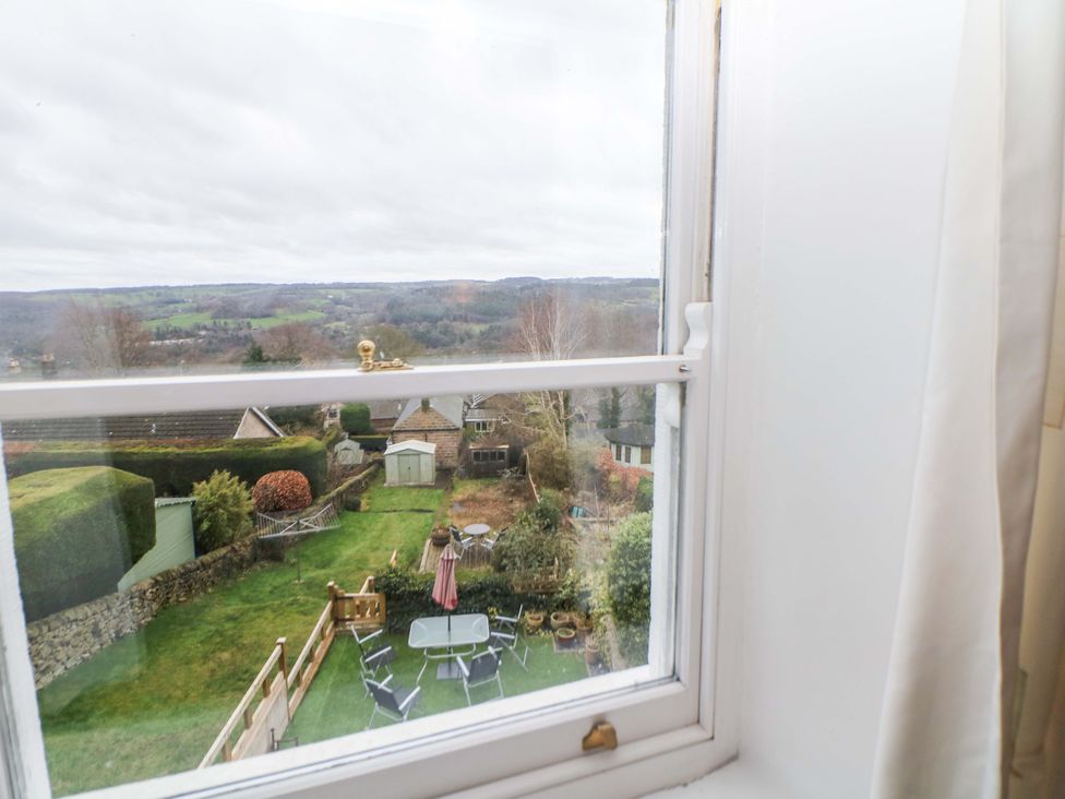 A view of a garden with table and chairs from a window at Nature’s Retreat in Matlock