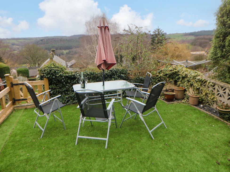 A garden with a table and chairs under an umbrella at Nature’s Retreat in Matlock
