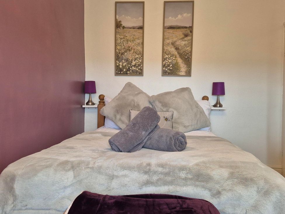 A bedroom with a bed and two framed pictures at Nature’s Retreat in Holloway
