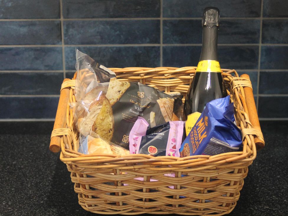 A basket with snacks and sparkling wine at Nature’s Retreat in Holloway