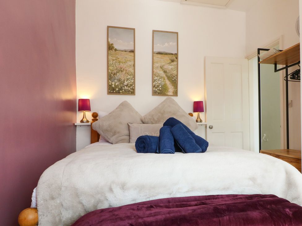 A bedroom with a bed and paintings on the wall at Nature’s Retreat in Holloway