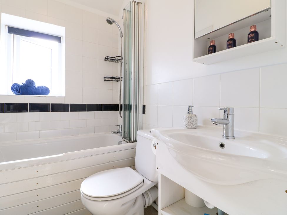 A bathroom with a bathtub, shower, sink and towels at Nature’s Retreat in Holloway