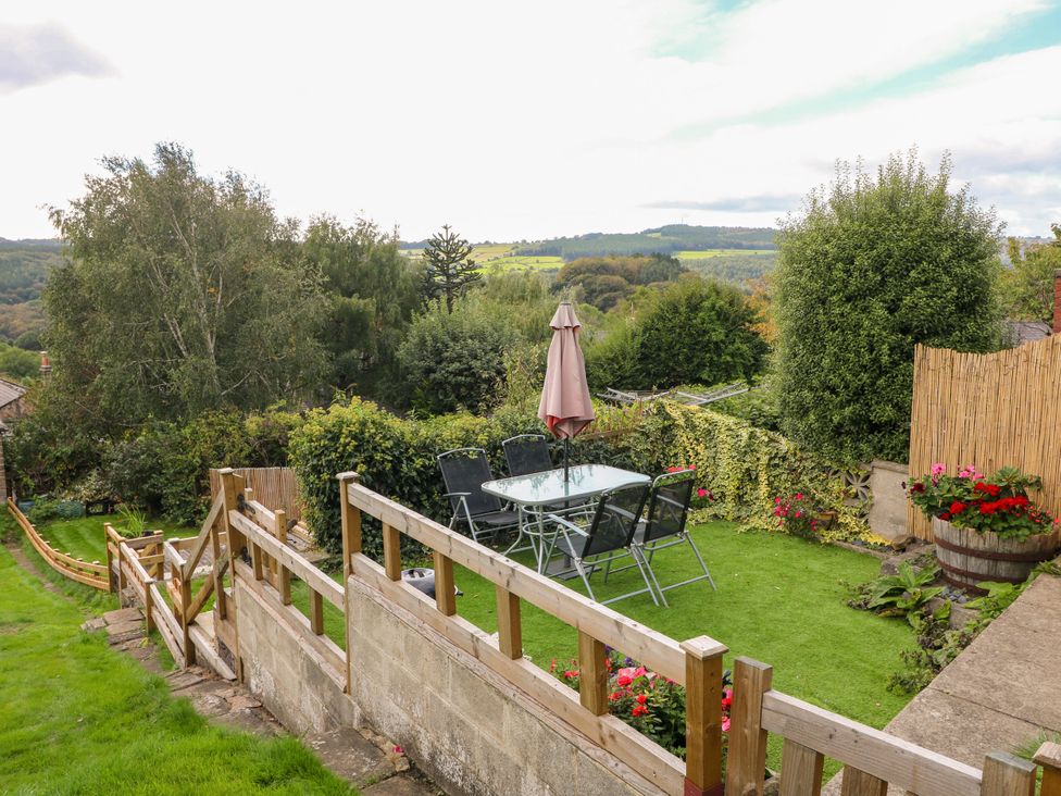 A garden with a table and chairs under an umbrella at Nature’s Retreat in Holloway