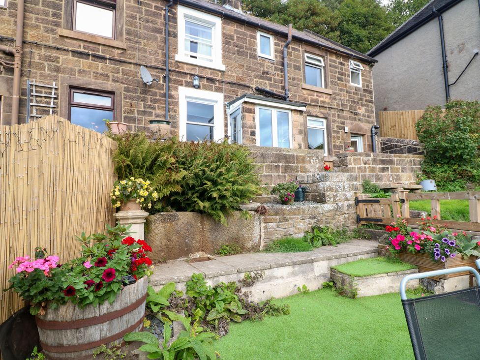 A garden with flower pots and a stone house at Nature’s Retreat in Holloway