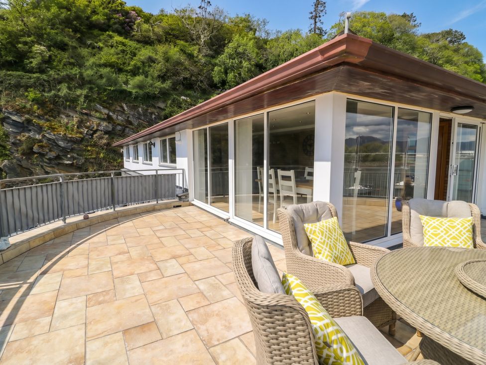 A balcony with chairs and a table at The Boat Yard Apartment in Porthmadog