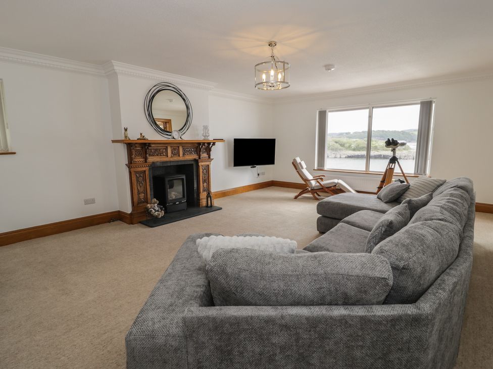 A living room with a fireplace and sofa at The Boat Yard Apartment in Porthmadog
