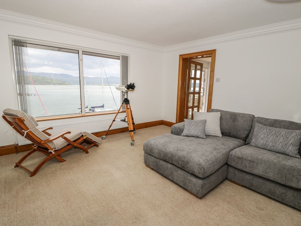 A living room with a telescope and a sofa at The Boat Yard Apartment in Porthmadog