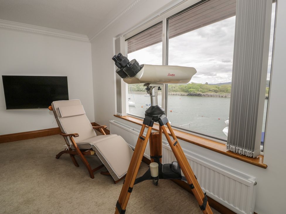 A living room with a telescope and reclining chair at The Boat Yard Apartment in Porthmadog