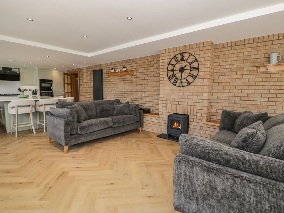 A living room with a fireplace and sofas at The Boat Yard Apartment in Porthmadog