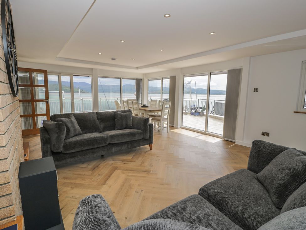 A living room with a sofa and dining area at The Boat Yard Apartment Porthmadog