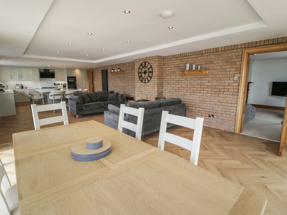 A living room with a sofa and a dining area at The Boat Yard Apartment Porthmadog