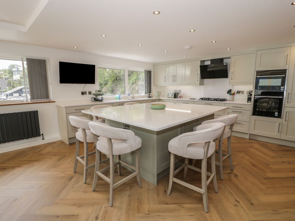 A kitchen with an island and bar stools at The Boat Yard Apartment Porthmadog