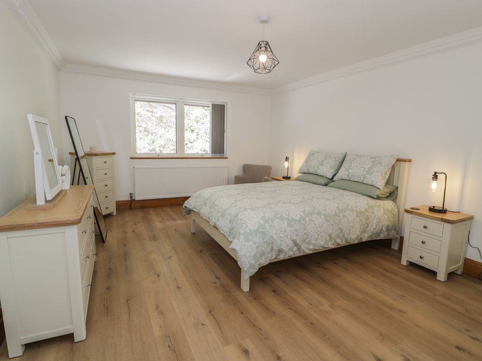 A bedroom with a bed and seating area at The Boat Yard Apartment in Porthmadog