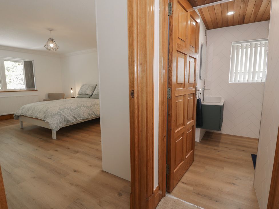 A bedroom with a bed and a sink at The Boat Yard Apartment Porthmadog
