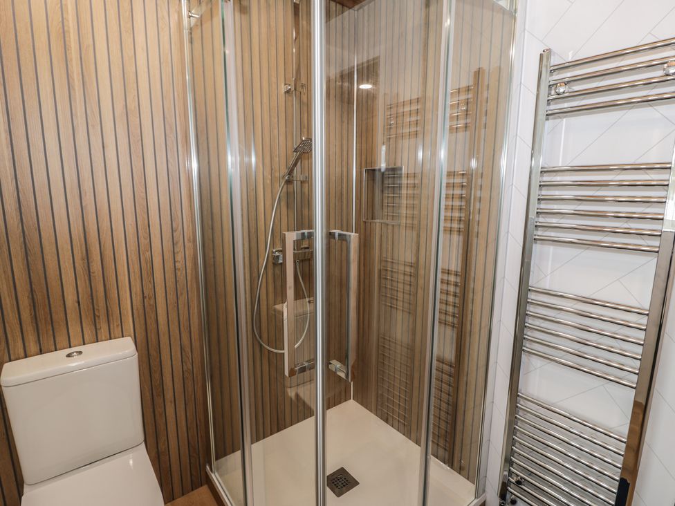 A bathroom with a shower and toilet at The Boat Yard Apartment in Porthmadog