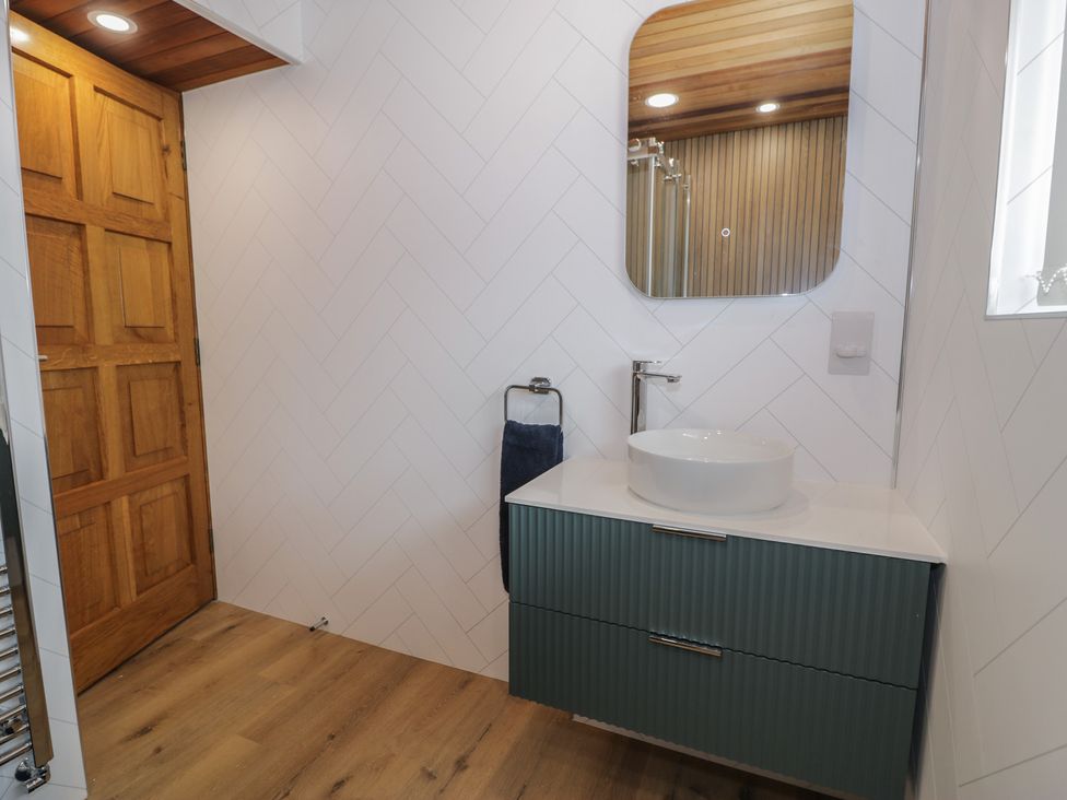 A bathroom with a sink and mirror at The Boat Yard Apartment in Porthmadog