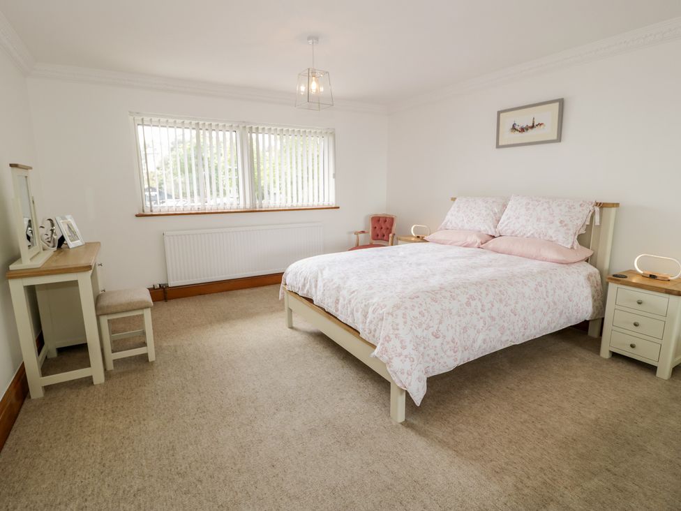 A bedroom with a bed and dressing table at The Boat Yard Apartment Porthmadog