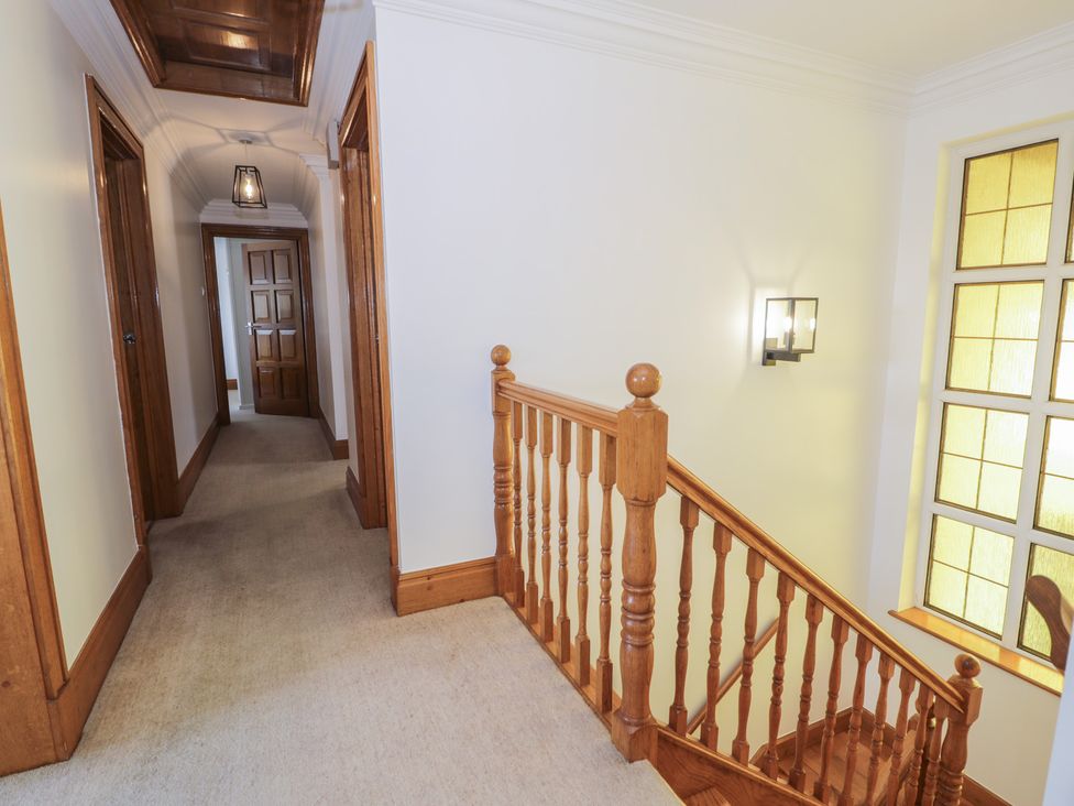 A hallway with stairs and light fixture at The Boat Yard Apartment in Porthmadog