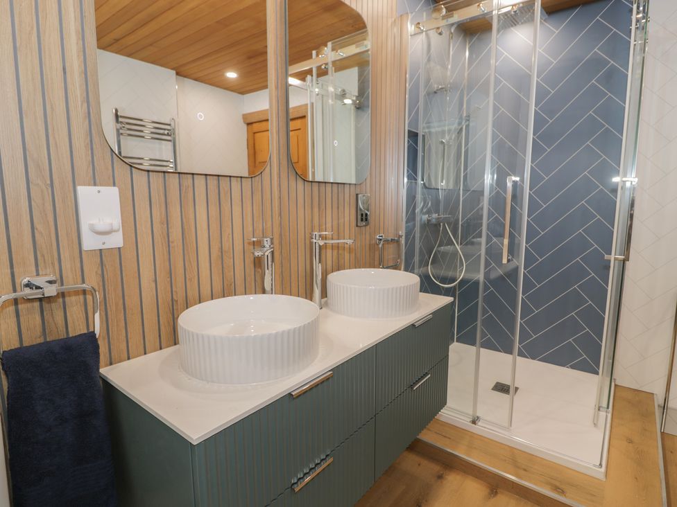 A bathroom with sinks and a shower at The Boat Yard Apartment in Porthmadog
