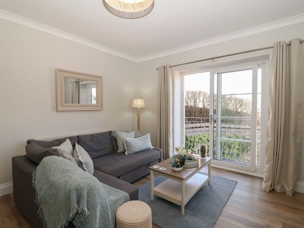 A living room with a sofa and coffee table at 3 The Elms in Salcombe