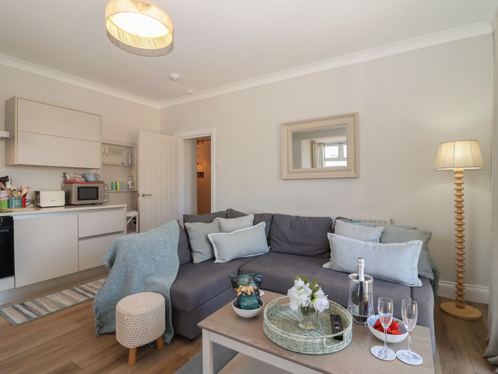 A living room with a sofa and coffee table at 3 The Elms in Salcombe