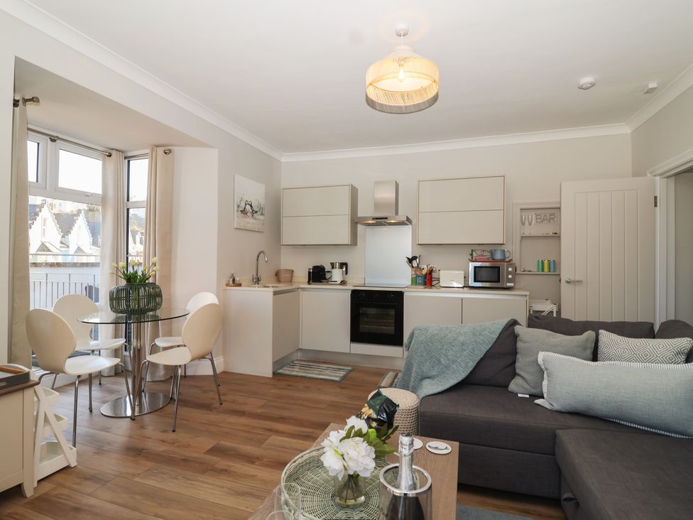 A kitchen with dining table and living area at 3 The Elms Salcombe