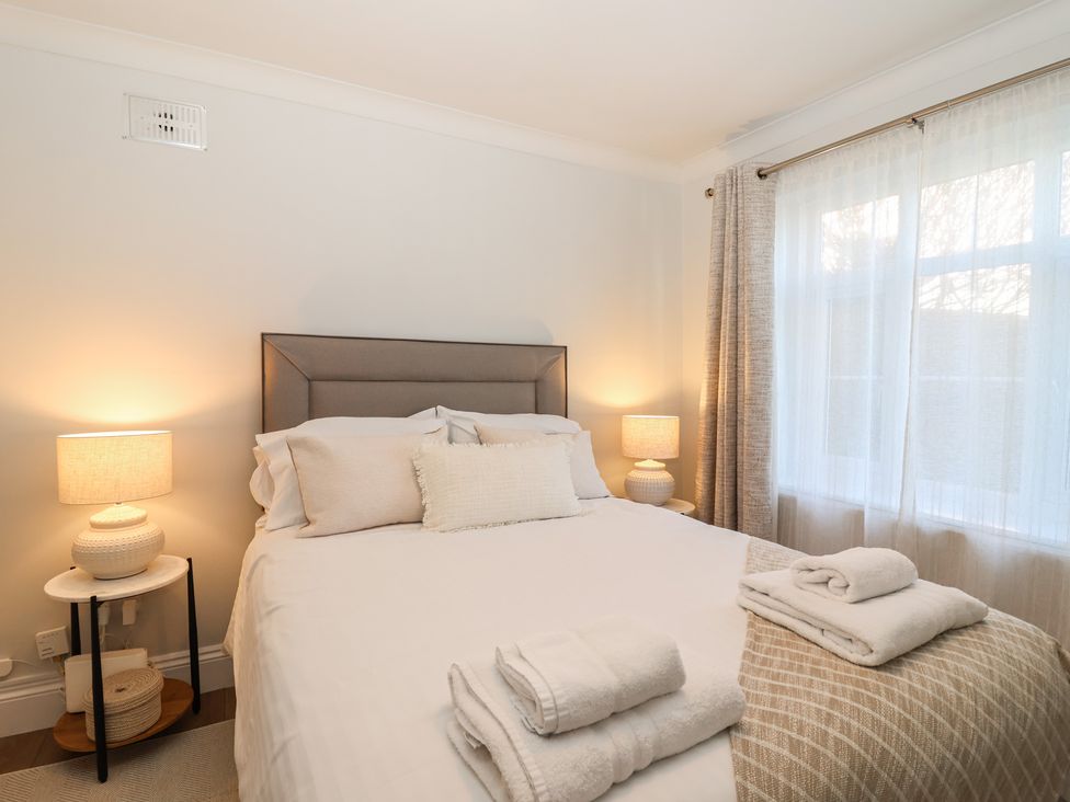 A bedroom with a bed and bedside lamps at 3 The Elms in Salcombe