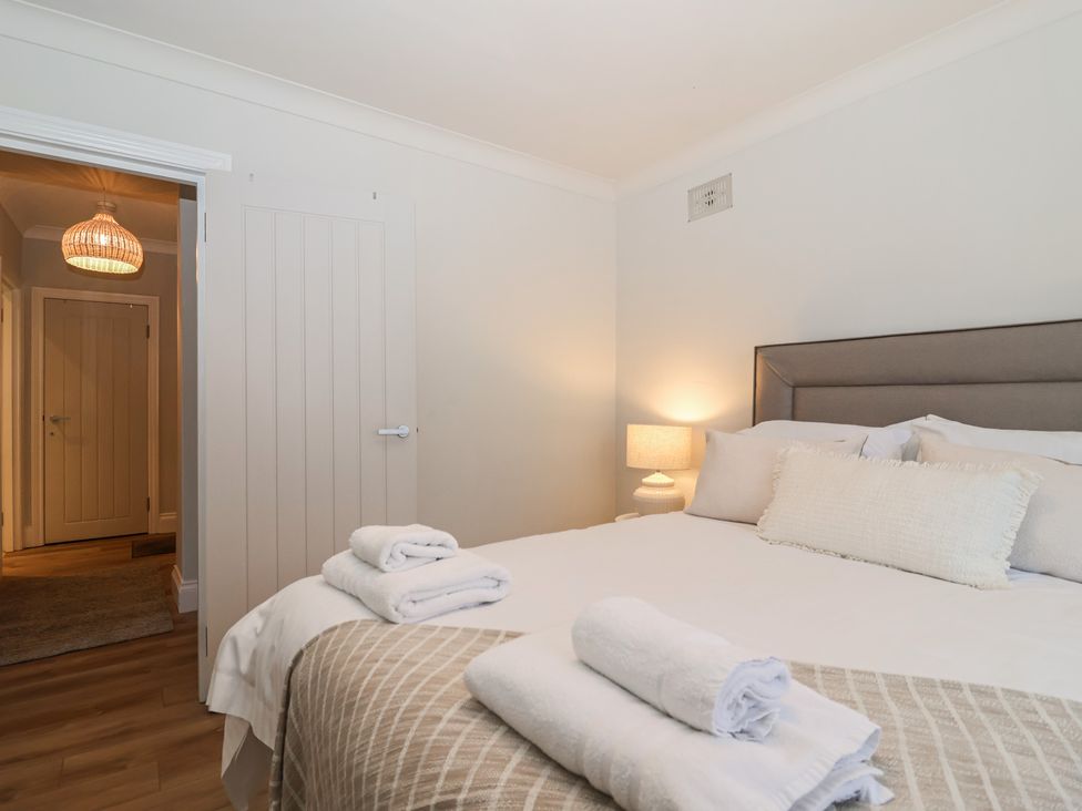 A bedroom with a bed and towels at 3 The Elms Salcombe
