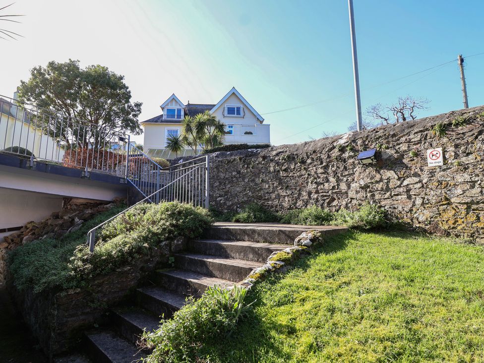 A set of stairs leading to a house surrounded by grass at 3 The Elms in Salcombe